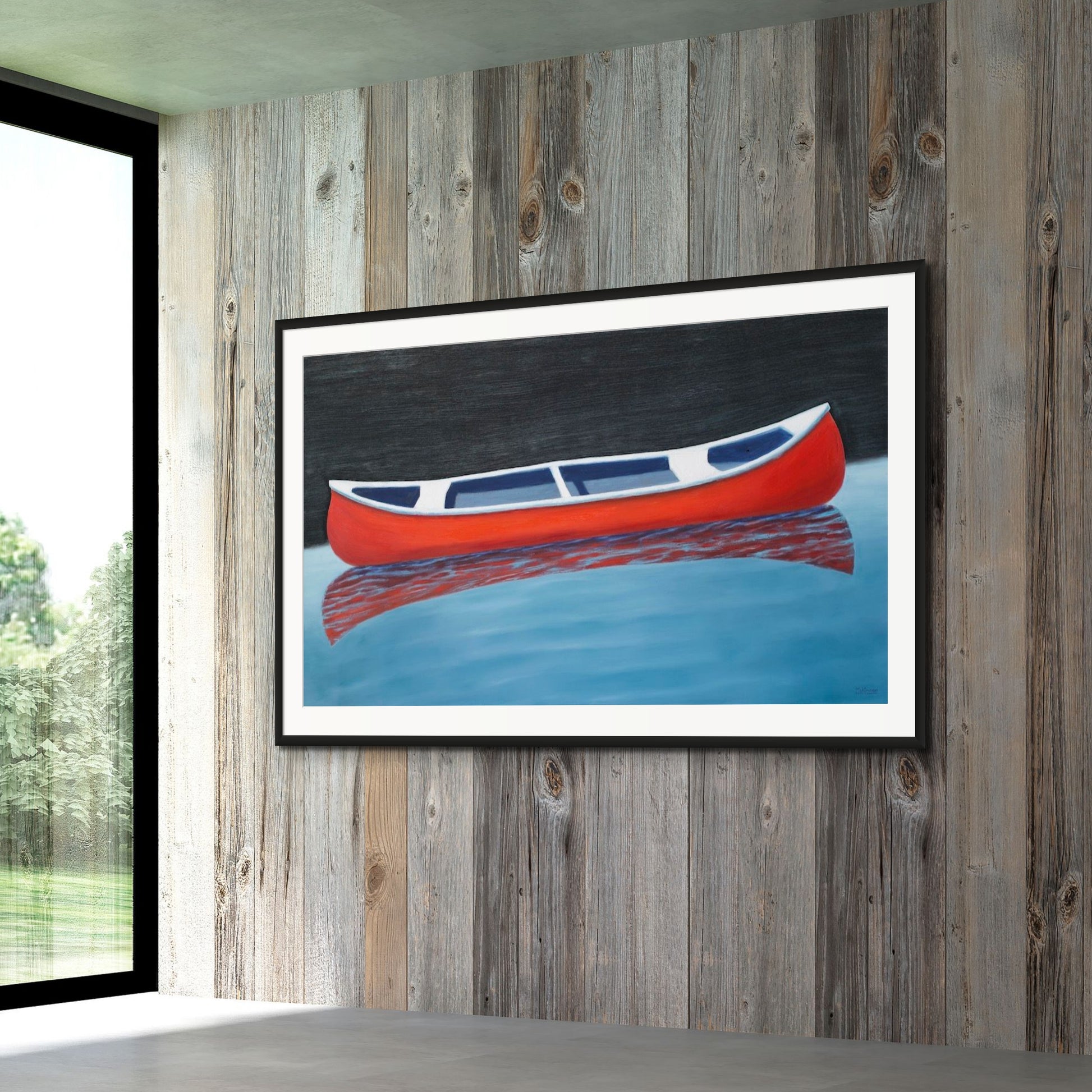 Canoe painting of a small red boat by Canadian artist Catherine McKinnon. The red canoe is floating on almost still blue water in the foreground and the background is pitch black. The giclee print is framed in black with white matting. It is mounted on a gray wooden wall.