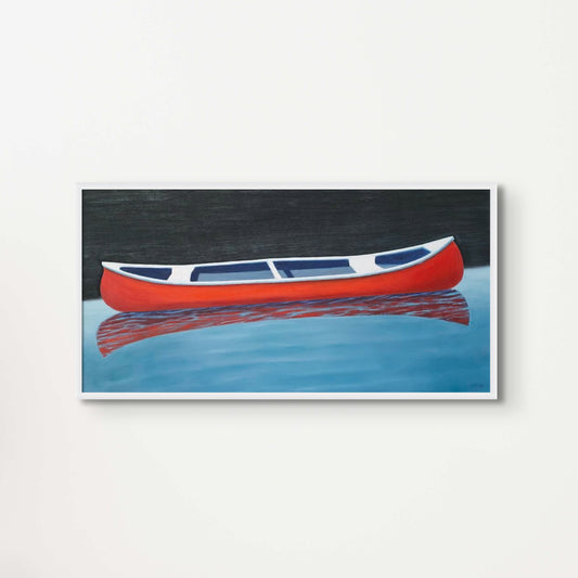 Canoe painting of a small red boat by Canadian artist Catherine McKinnon. The red canoe is floating on almost still blue water in the foreground and the background is pitch black. The giclee print is framed in white and mounted on a light gray wall.