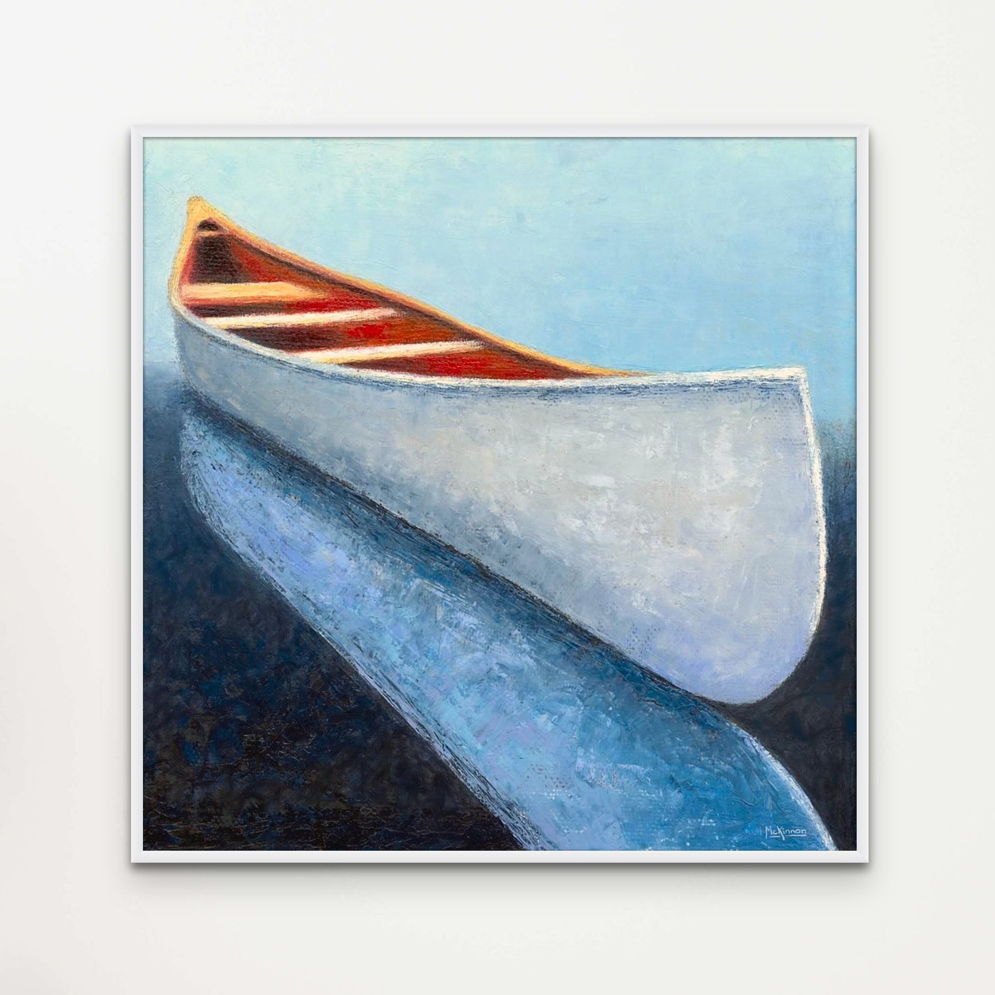 A coastal painting of a white canoe reflected in dark, navy blue water by Canadian artist Catherine McKinnon. This giclee print of the art piece is framed in white and mounted on a light grey wall as modern farmhouse style wall decor.
